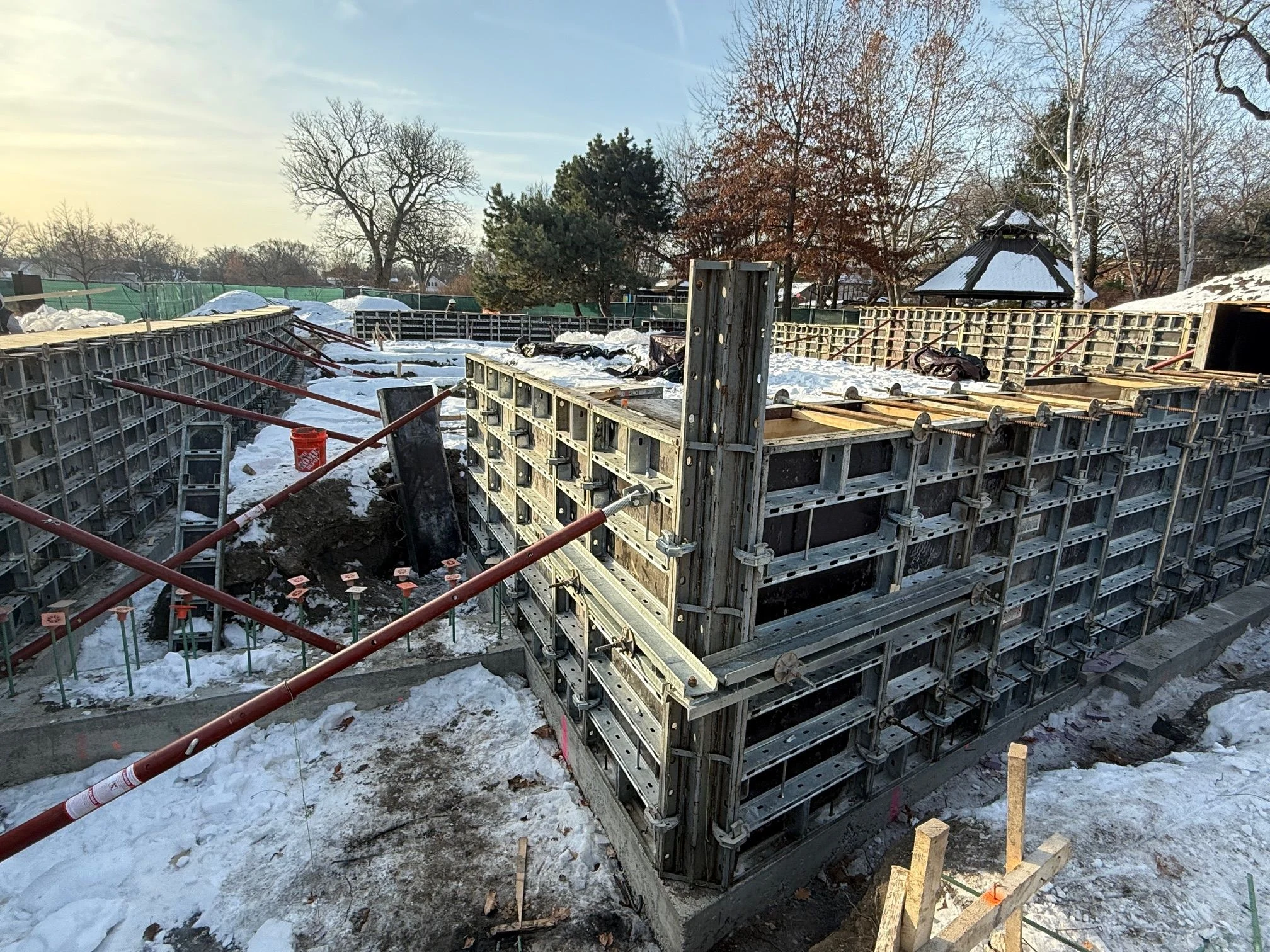 Field Park construction site with concrete forms and rebar in the snow.