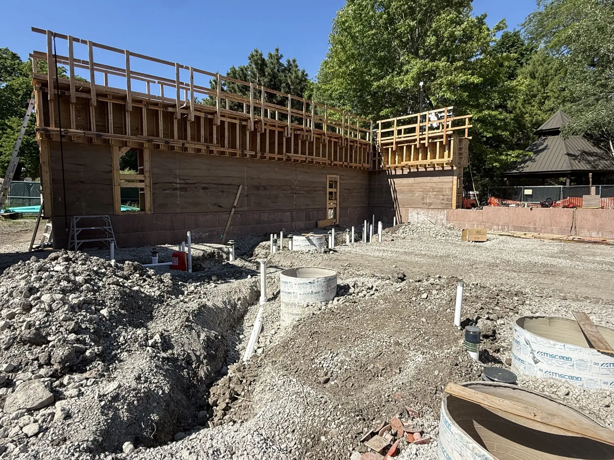 Construction of the Field Park building shows the foundation and framing. Trenches for plumbing are visible.