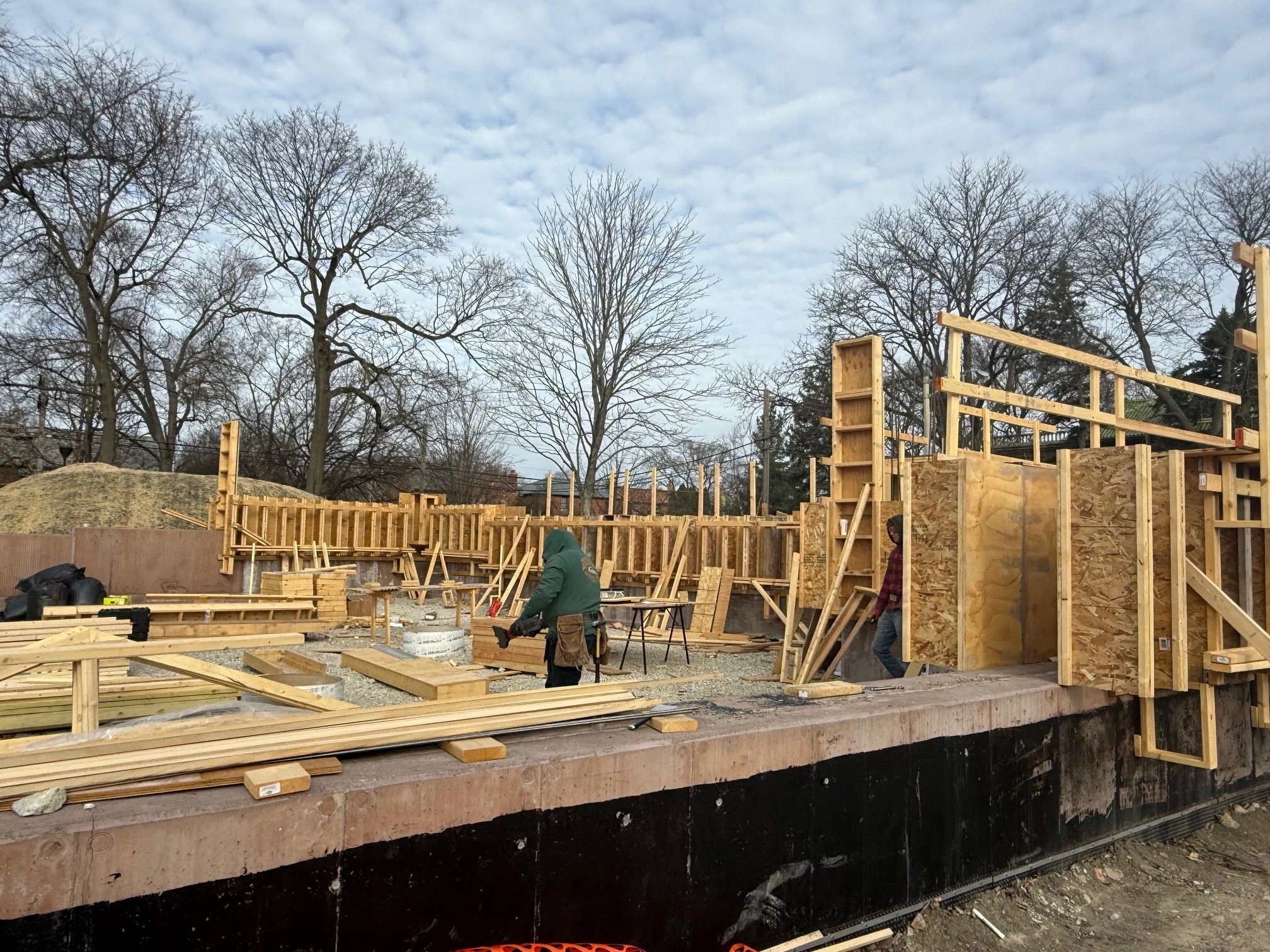 Construction workers build concrete forms for a new structure at Field Park.