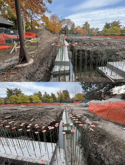 Construction site at Field Park showing trenches with concrete footings and rebar, with orange safety fencing in the
