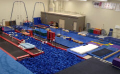 Gymnastics and Recreation Center with various apparatus including uneven bars, vaulting horses, foam pit, and trampolines.