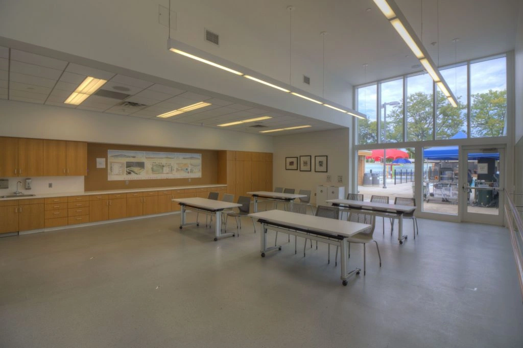 Interior of a multi-purpose room at Ridgeland Common Recreation Complex with tables, chairs, and a kitchenette.