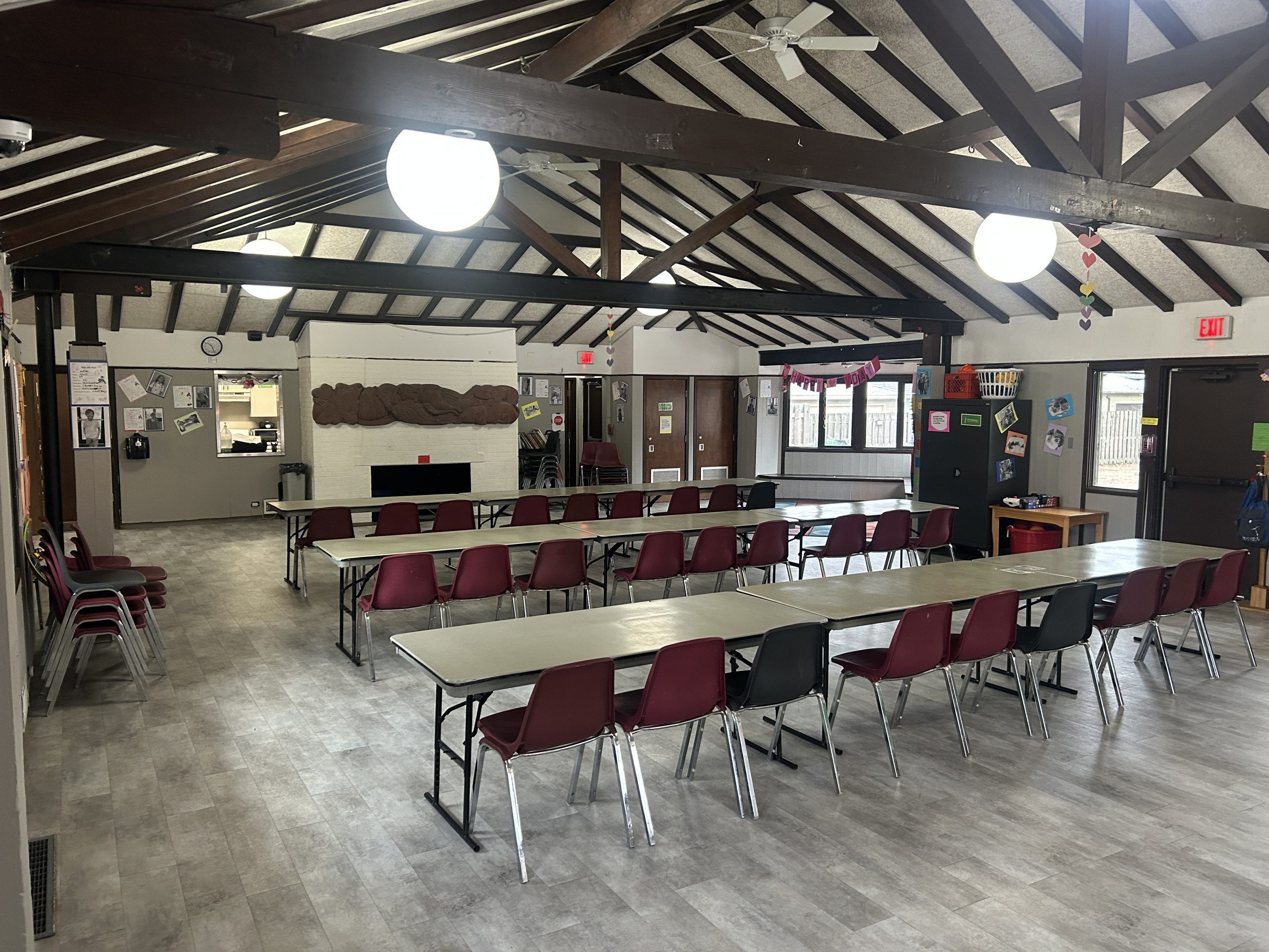 room with wood beams and tables set up in rows with chairs facing the front