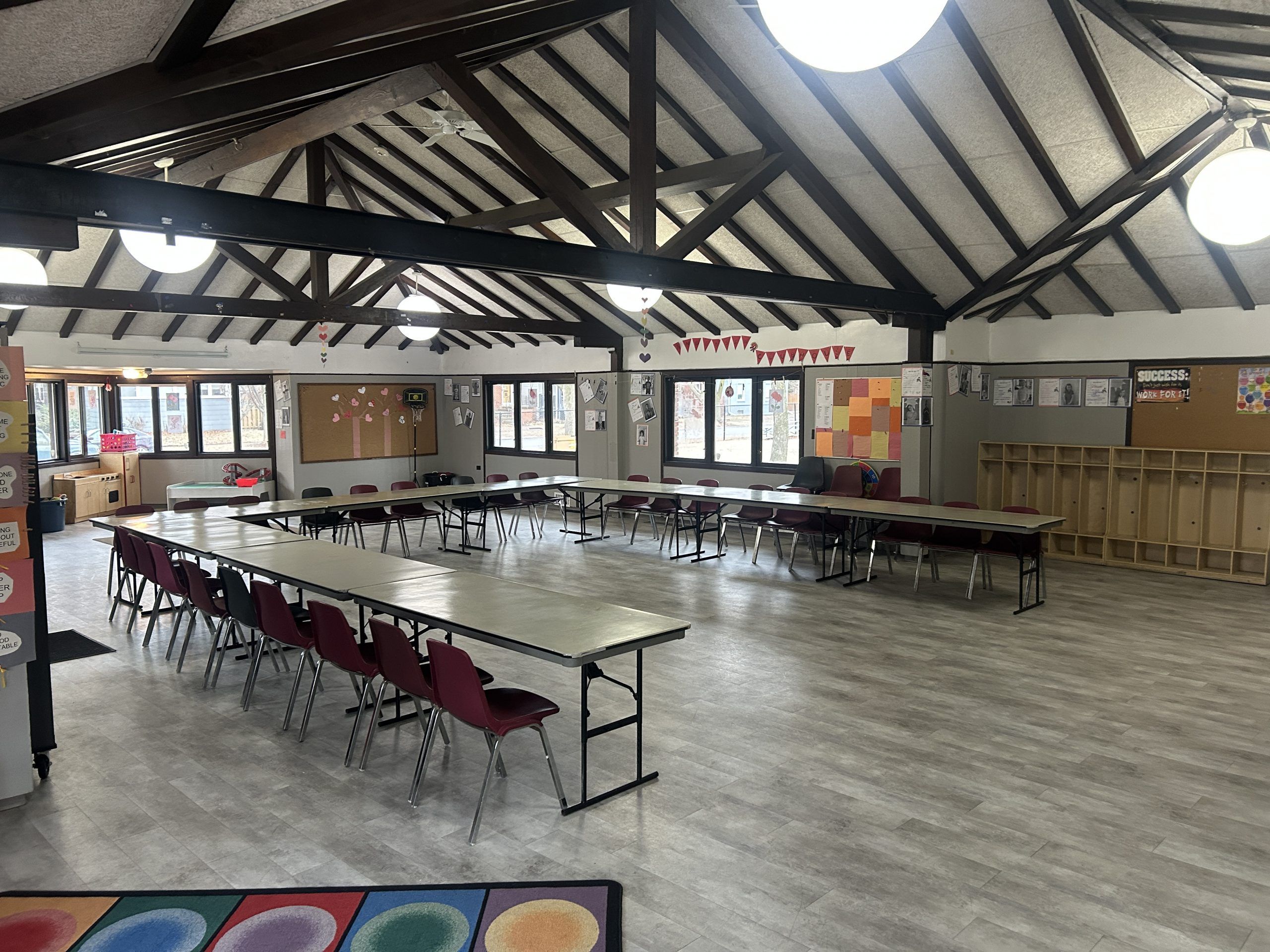 room with wood beams and table in a large u shape