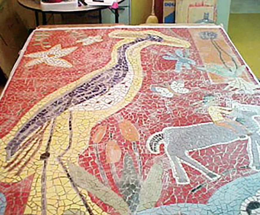 Mosaic artwork featuring a roadrunner, a horse with a rider, and desert flora against a red background.