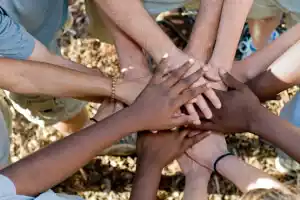 Diverse hands stacked together in a circle, symbolizing unity and collaboration for the Park District Citizen Committee.