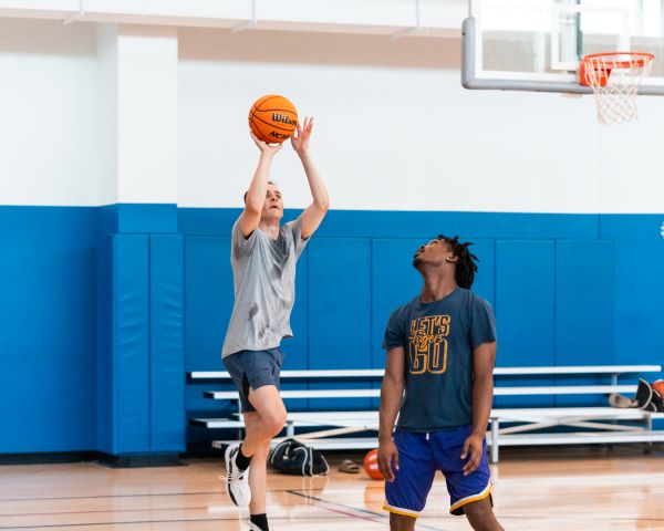 two men play basketball