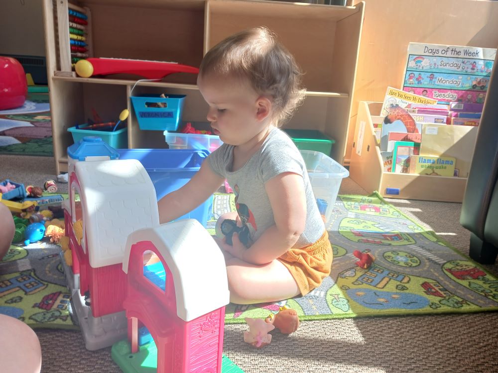 young child plays with toys at the cubhouse indoor playground