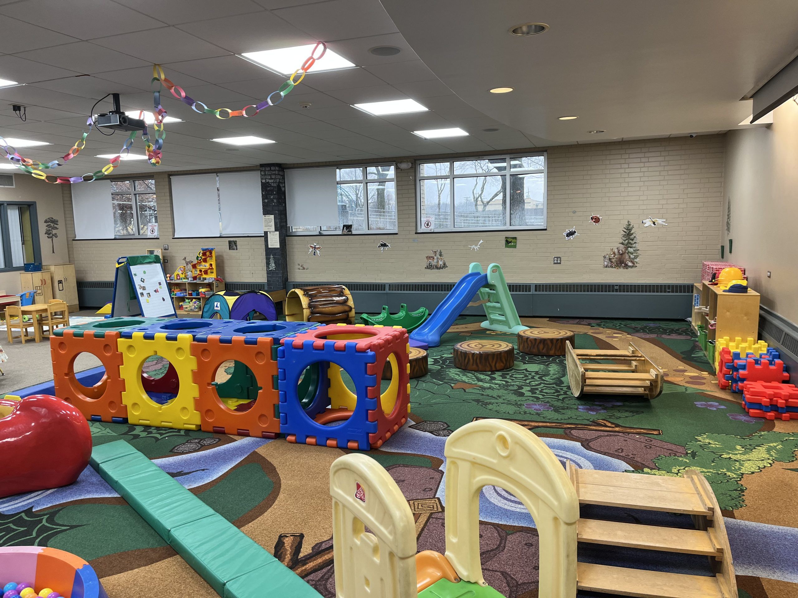 nature themed rug with climbing apparatus like slides, rockers, and steps